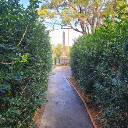 Hedge-lined path leading to the memorial obelisk and graveyard