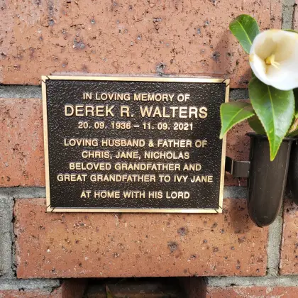 Bronze memorial plaque with a flower vase on the columbarium wall