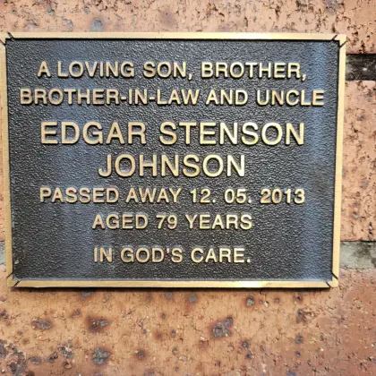 Close-up of a bronze memorial plaque on the columbarium wall